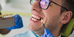 Man in glasses smiling while getting dental implants in Cambridge