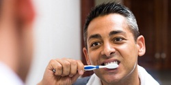 Man brushing his dental implants in Marietta