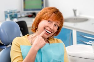 senior woman pointing to new tooth