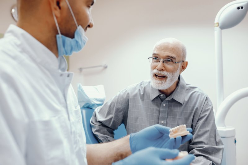 A dentist speaking with an older patient.