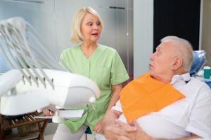 older man talking to implant dentist