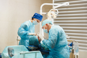 Two oral surgeons working on a patient’s mouth